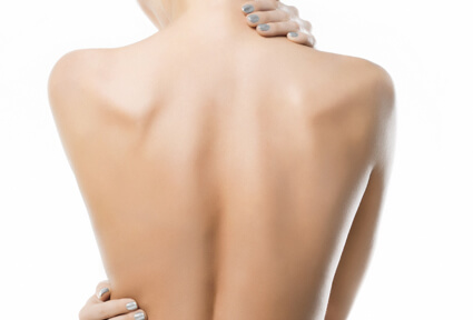 Picture of a woman with her back to the camera and happy with her perfect back liposuction procedure she had with top plastic surgeons in beautiful San José, Costa Rica, Mexico.  She has two hands positioned to highlight the areas of her back liposuction.