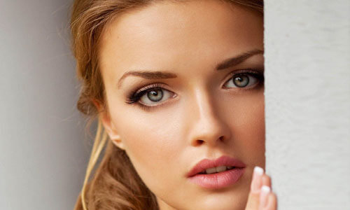 Close-up picture of a beautiful woman, happy with her eyelid lift in San José, Costa Rica.  The woman has medium length brown hair and is looking directly at the camera.