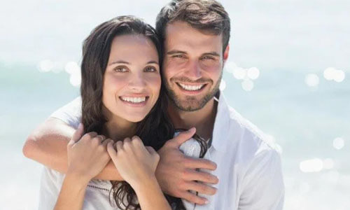 Picture of a man,  happy with his hair transplant  procedure he had in San José, Costa Rica.  The man is shown with his arm around a woman and both are smiling at the camera.