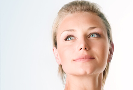 Picture of a woman with blonde hair, facing the camera, and happy with her perfect face lift procedure she had at Top Plastic Surgeons with  top plastic surgeons in beautiful San José, Costa Rica.  The woman is looking slightly upwards to show her satisfaction with her face lift.